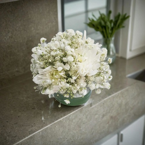 center piece white gypsophilia and white craze 1910 - This elegant center piece features a round vase filled with delicate baby's breath flowers, also known as white gypsophilia and white craze. Standing at a height of 15 cm and with a width of 10 cm, this arrangement adds a touch of sophistication and charm to any space.