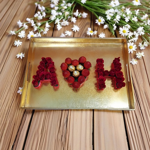 Fruit Flower - Two Letters 1208 - A golden tray made of acrylic with 2 baby roses letters ,10 strawberries in a heart shape and 3 ferrero rocher chocolates Size : Hight 21cm. Width 32cm.