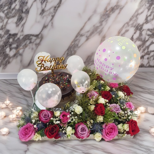 Birthday Cake 1902 - The tray Includes Red and Pink, White Baby Roses, Eryngium, Wax Flower, Gypsophila, And Green The Arrangement Contains 7 inch chocolate cake for 2 to 4 person and  Balloons In A tray. Height 35 cm Width 50 cm