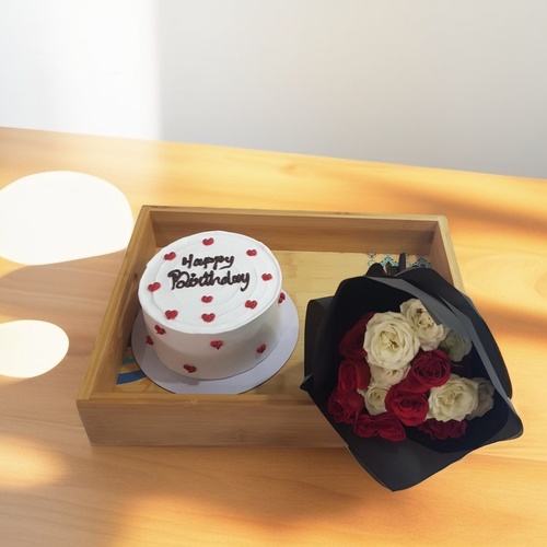 Cake And Hand Bouquet  1913 - Celebrate any occasion with this delightful set featuring a vanilla cake that serves four, beautifully paired with a hand bouquet of red and white baby roses. Arranged on a charming wooden tray, this combination makes for a perfect gift, adding a touch of elegance to your festivities. Enjoy the sweet flavors of the cake alongside the fresh blooms, creating a memorable experience for you and your loved ones.Height 15 cmWidth 36 cm
Length 26 cm