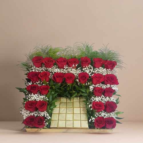 Roses with gypsophila and wafer chocolate in a golden acrylic tray 1718 - This exquisite arrangement features vibrant roses complemented by delicate white gypsophilia and lush greenery, creating a stunning visual appeal. The addition of Italian rescus enhances the overall elegance, in addition to the flowers are 25 pieces of wafer chocolates in a golden acrylic tray.  Perfect all occasions, this floral display will impress and convey heartfelt sentiments. height 30 cm width 48 cm length 35 cm