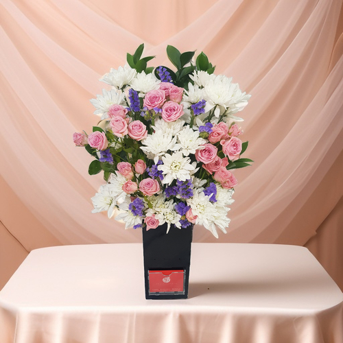 White Craze Flower With Baby Rose In Acrylic Vase 530 - Elevate your home decor with this stunning vase arrangement featuring delicate white craze flowers, lovely baby roses, and vibrant purple statics, all gracefully complemented by lush green rescus. this eye-catching piece is set in a sleek acrylic vase. Whether it's for a special occasion or everyday elegance, this floral arrangement adds a pop of color and charm to your space. Standing at an impressive height of 60 cm and a width of 35 cm.