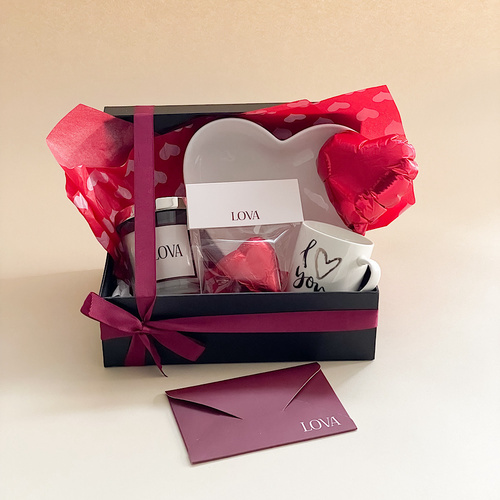 Love you - The product contains an aromatic candle with chocolate, a small cup, a white heart-shaped plate, and a small balloon with a red heart.